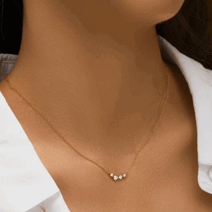 Gold-tone chain necklace with three clear stones in a small dangling cluster