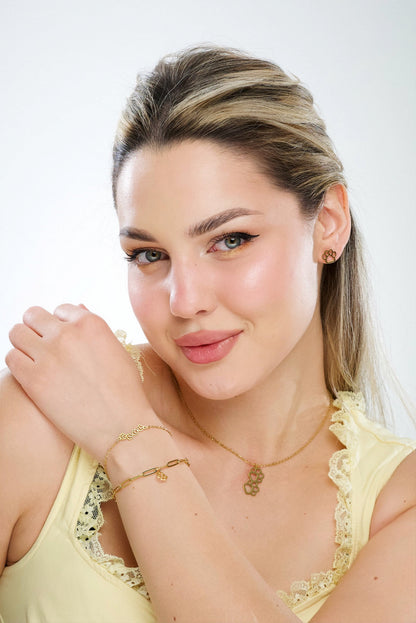Gold-tone paw print stud earrings on model with short hair