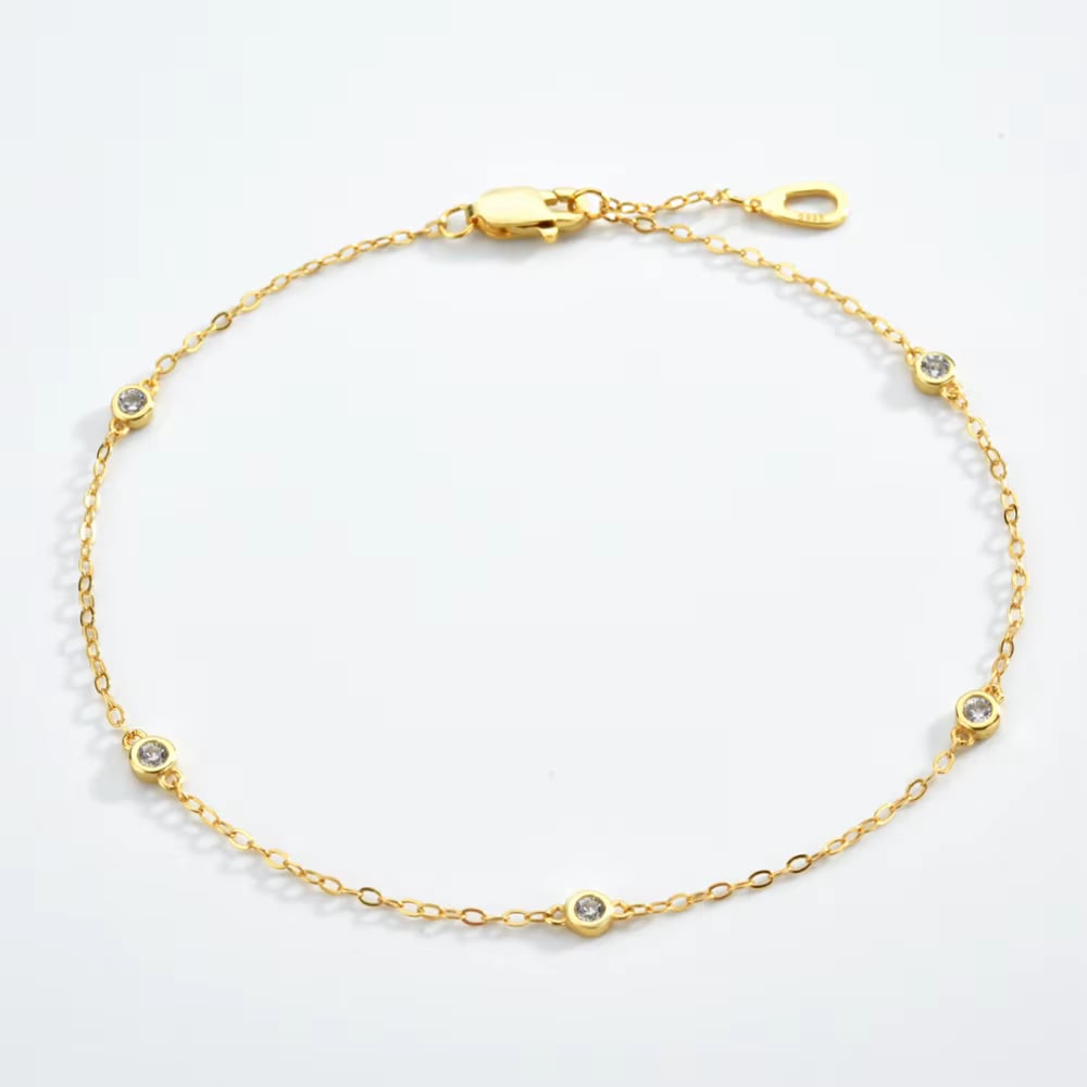 Gold cubic zirconia bezel link bracelet with round stones and lobster clasp