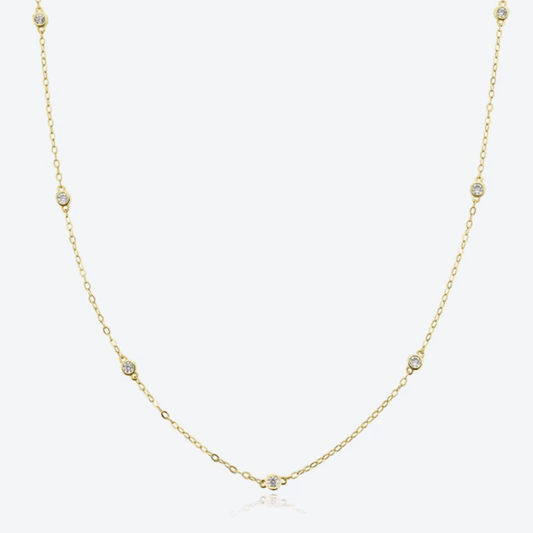 Gold-tone dainty necklace with round cubic zirconia halo bezel accents along chain