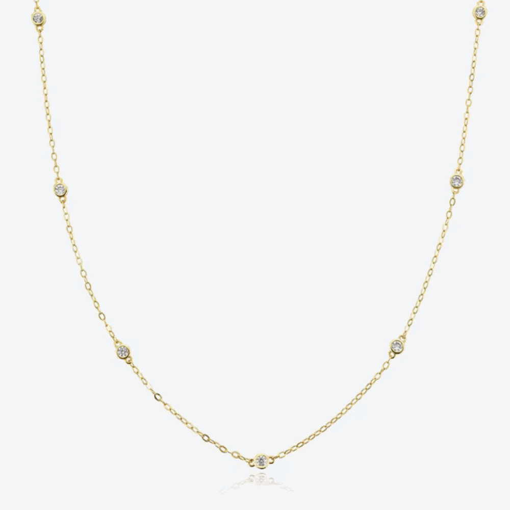 Gold-tone dainty necklace with round cubic zirconia halo bezel accents along chain