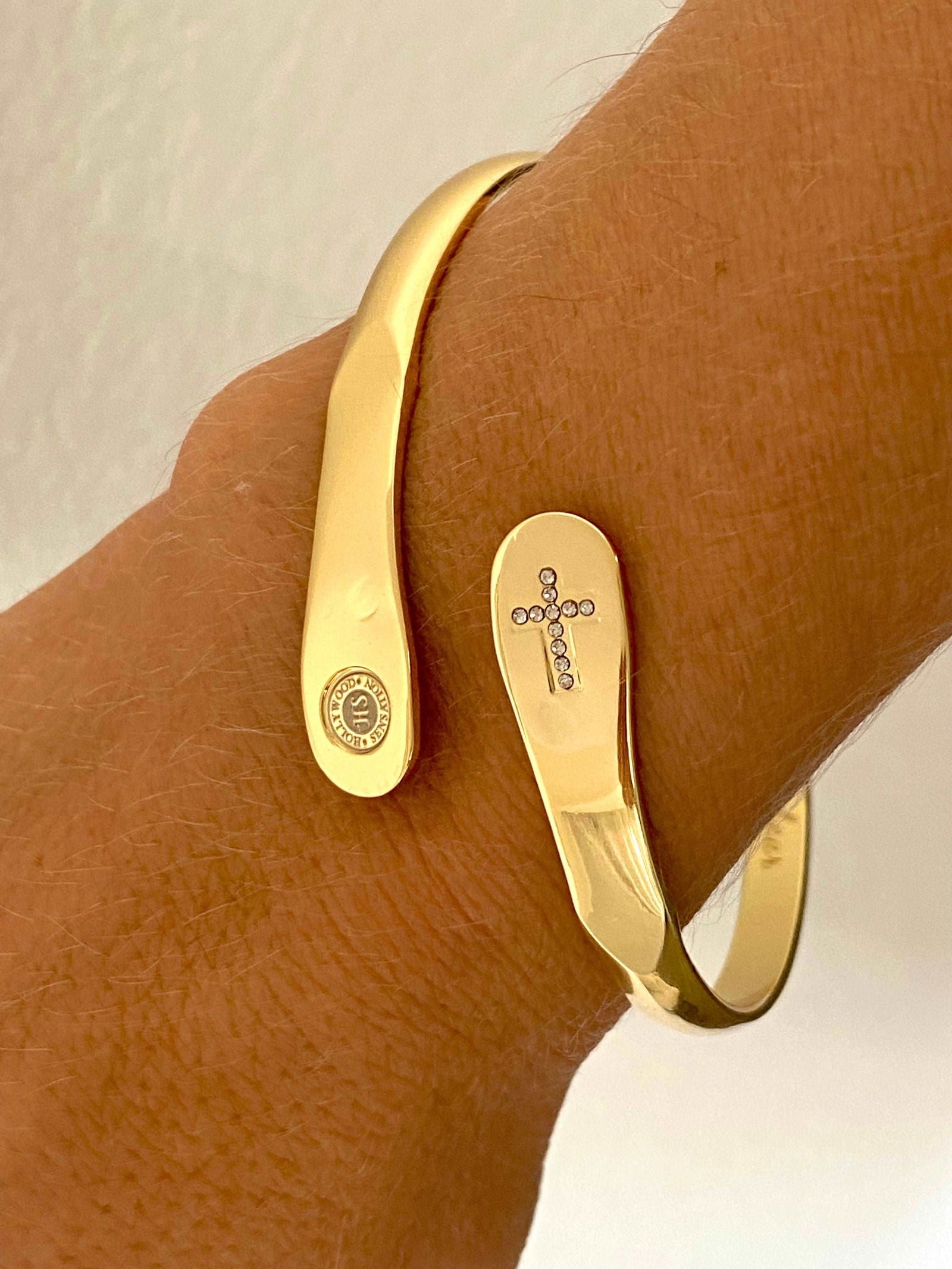 Gold bracelet with cross charm detail and oval engraved tag