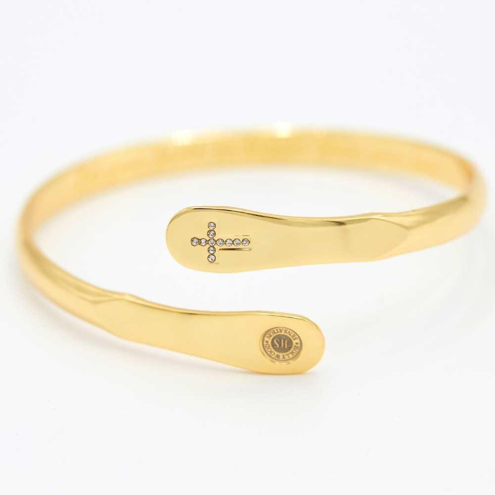 Gold cross bracelet with crystal cross motif on flat oval centerpiece and oval tag