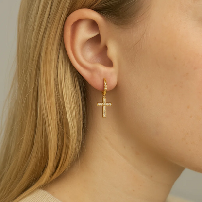 Gold cross dangle cubic zirconia earrings worn, close side view
