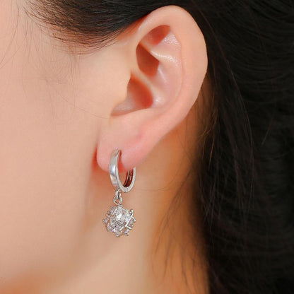 Silver hoop earrings with cubic zirconia snowflake drop on ear