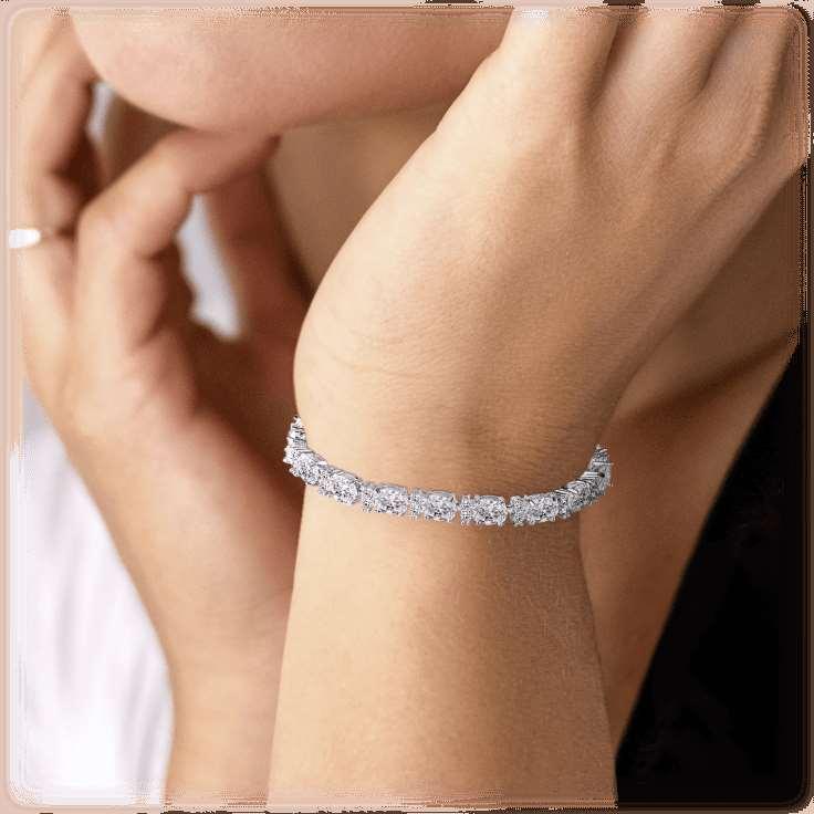 Silver-tone tennis bracelet worn on wrist with row of sparkling cubic zirconia stones