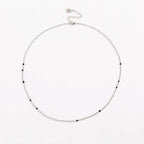 Silver link necklace with small black bead stones along the chain
