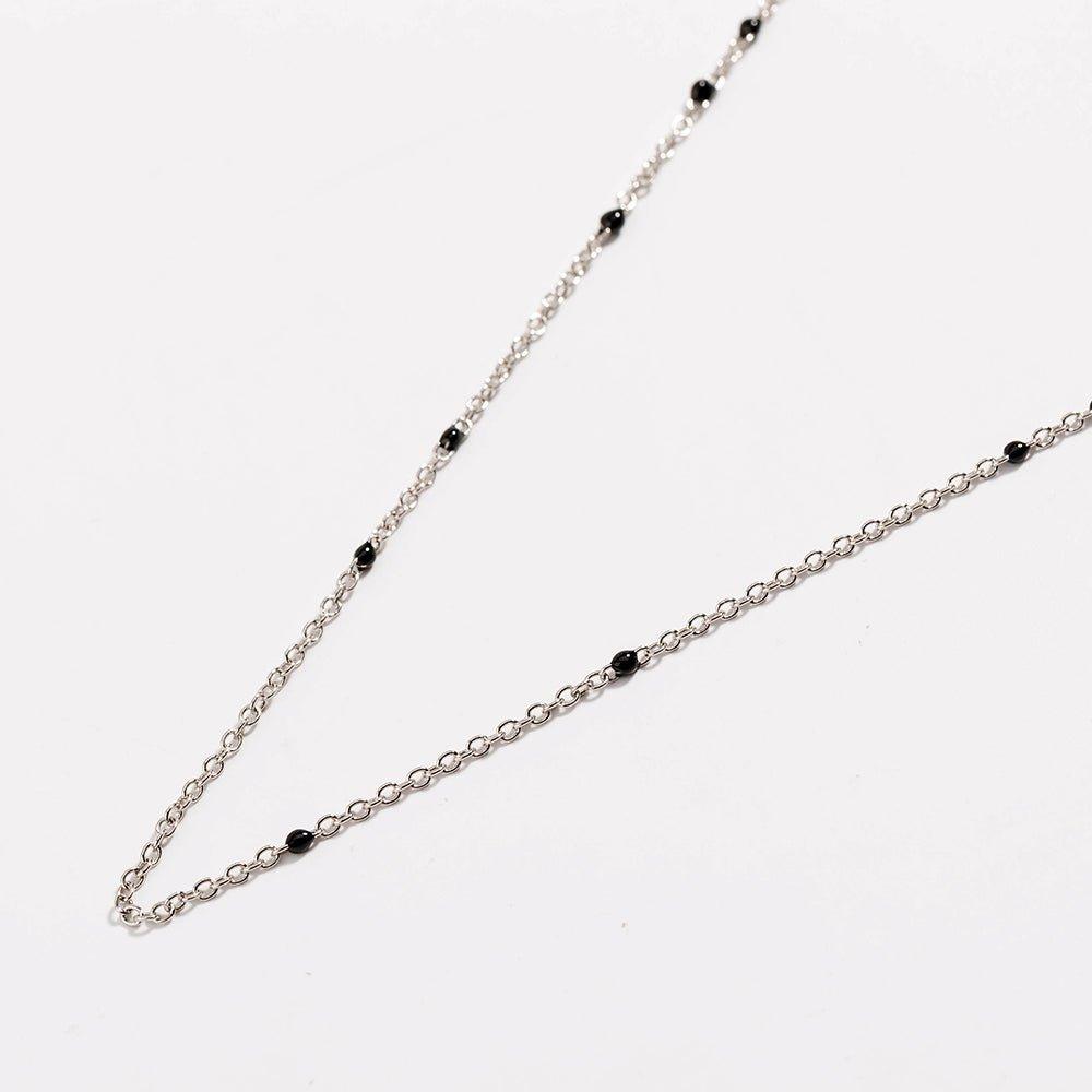 Silver link necklace detail with black bead stations along the chain