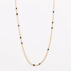 Gold link necklace with black bead stations along the chain