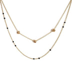 Gold-tone beaded link necklace with black beads and small heart charm.
