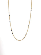 Gold-tone beaded link necklace with black onyx-style beads, partial close-up.