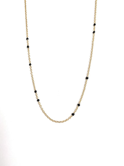 Gold-tone beaded link necklace with black onyx-style beads, partial close-up.
