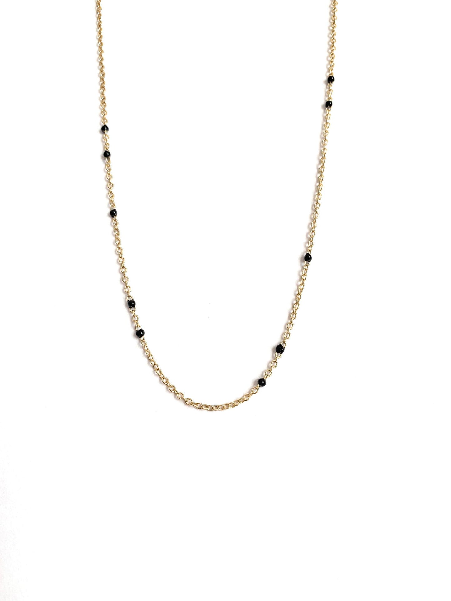 Gold-tone beaded link necklace with black onyx-style beads, minimal close V.