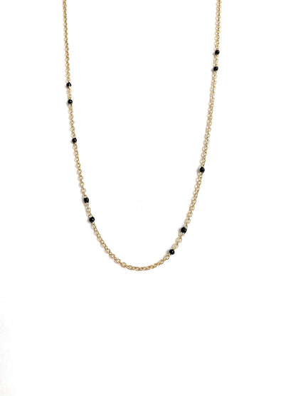 Gold-tone beaded link necklace with black onyx-style beads, minimal close V.