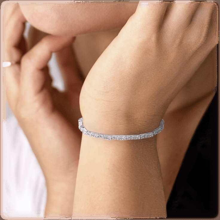 Cubic zirconia tennis bracelet worn on wrist, slim row of clear stones, silver-tone