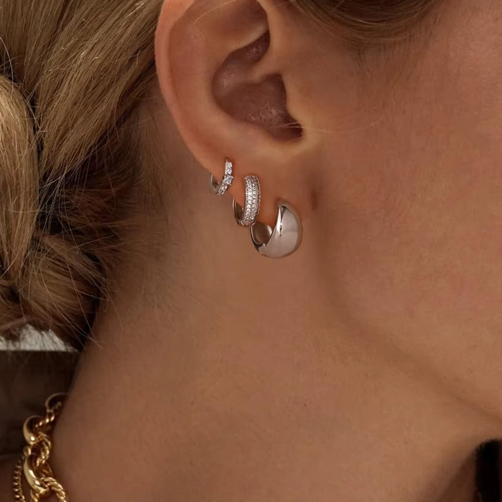 Dainty huggie hoop earrings, three silver pairs on ear