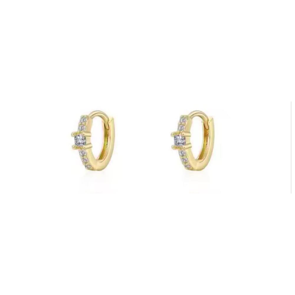 Gold huggie hoop earrings with clear stones accenting the front