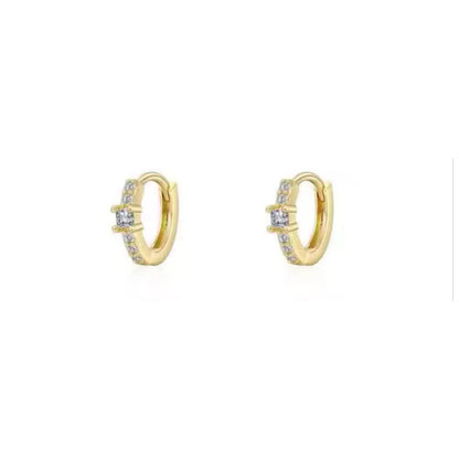 Gold huggie hoop earrings with clear stones accenting the front