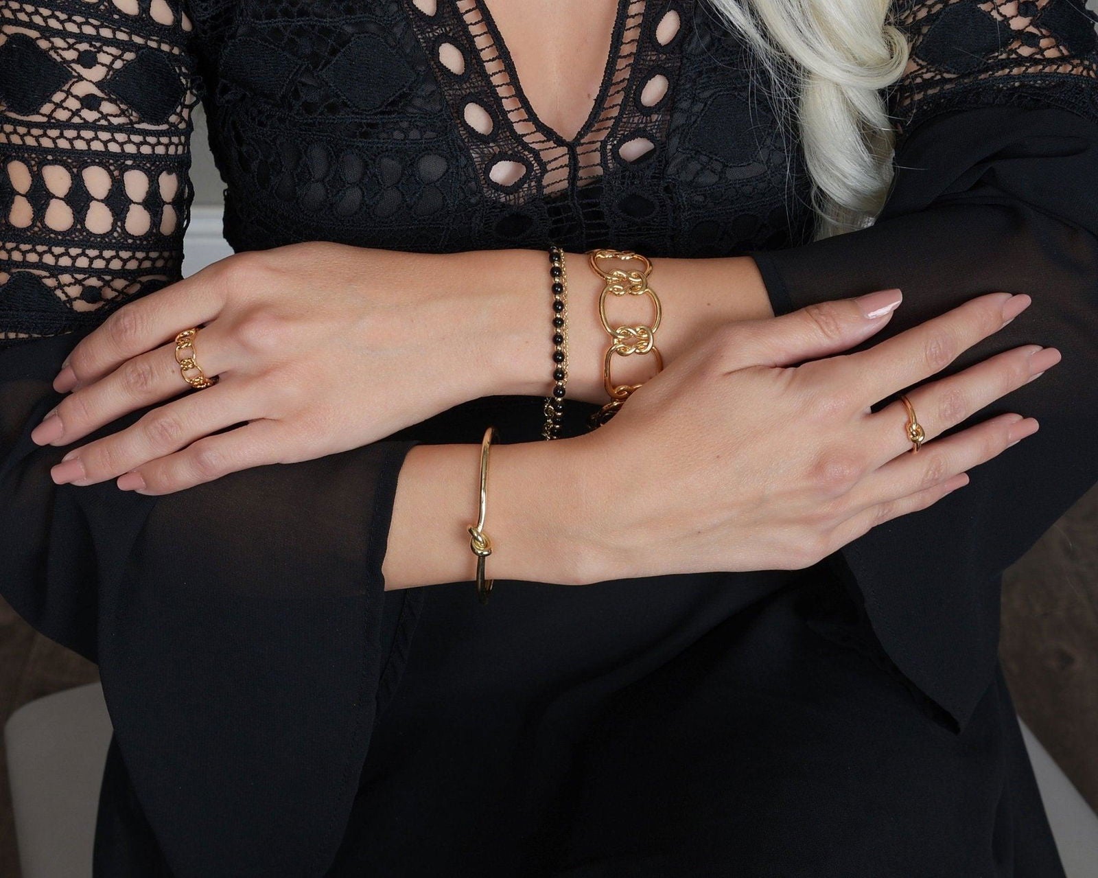 Gold love-knot bracelet on wrist with twisted knot clasp