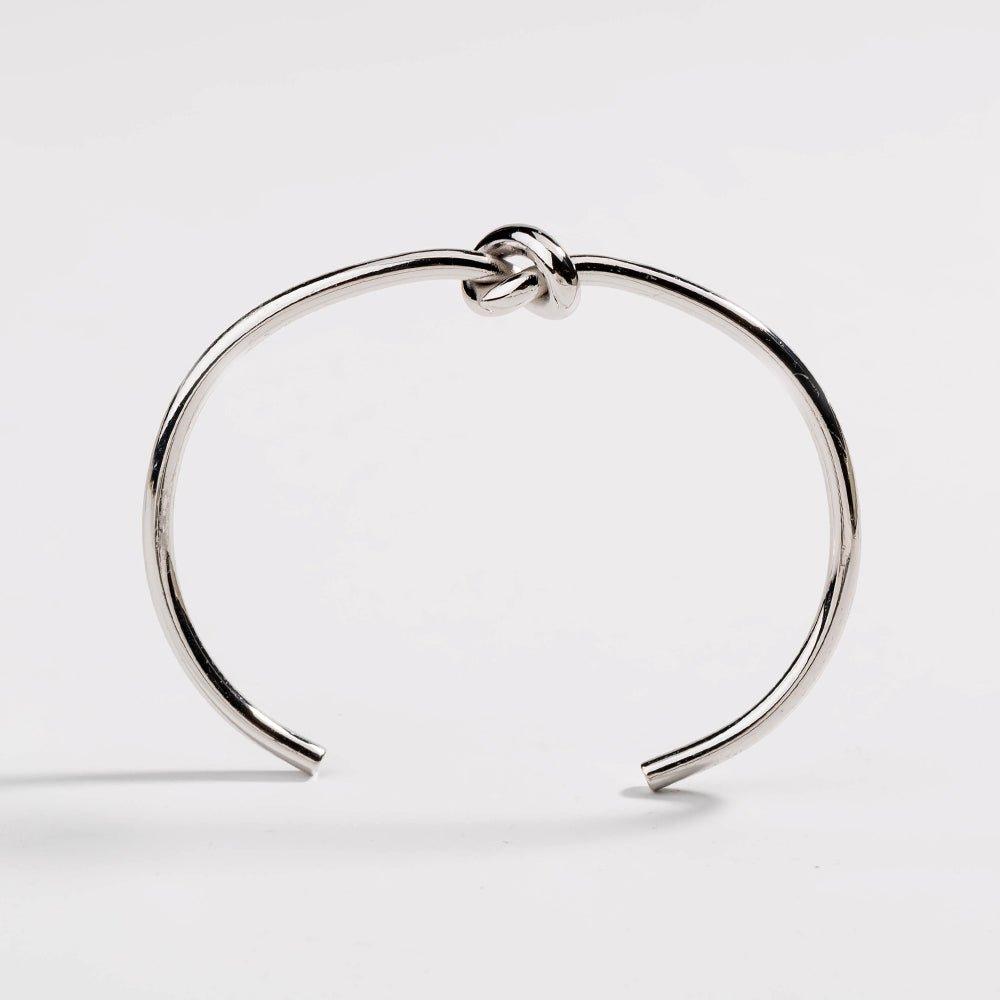 Silver love-knot bracelet with twisted knot clasp on a slim round bangle