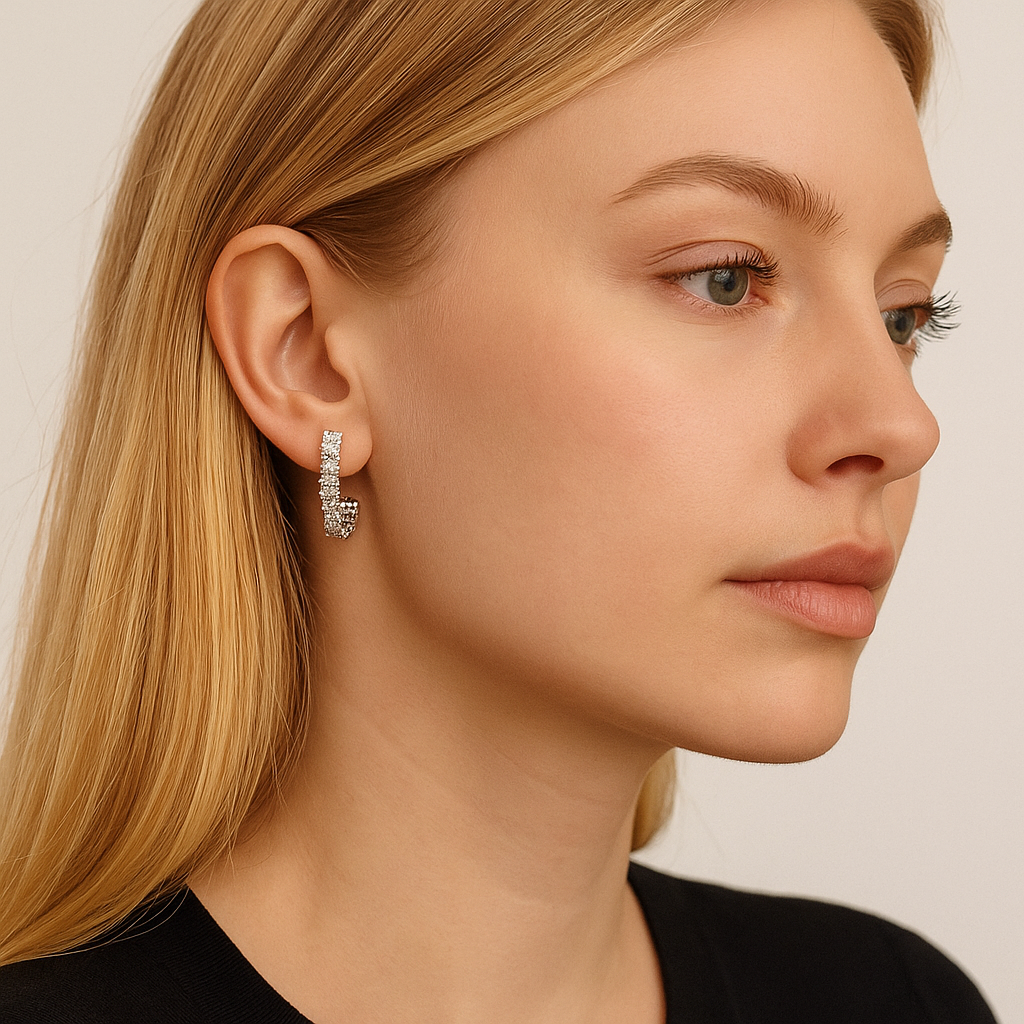 Gold cubic zirconia J hoop earrings worn, small hoop with dangling sparkle detail