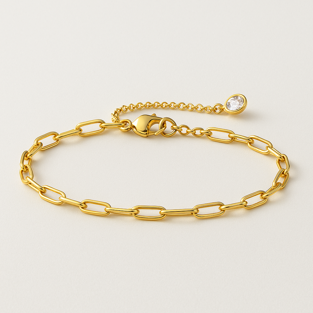 Gold paperclip link bracelet with round stone detail and clasp, laid flat