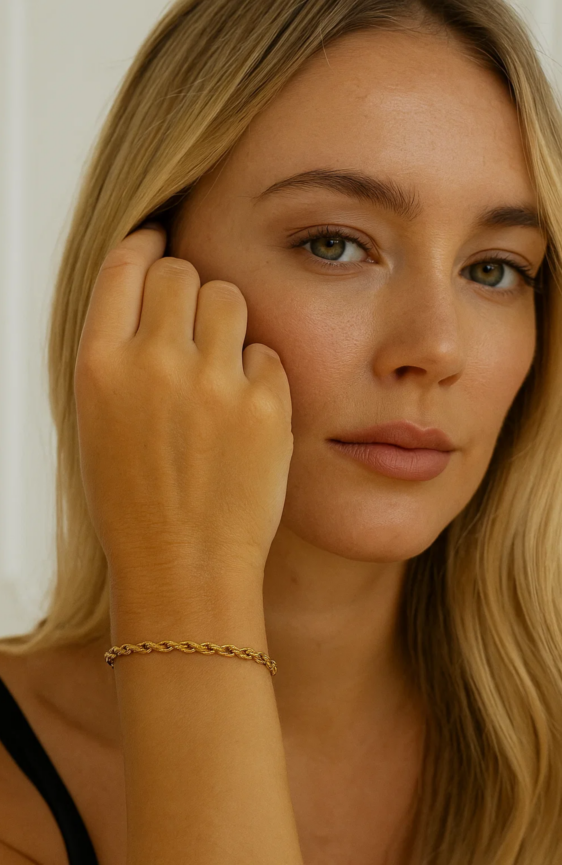 Gold braided rope bracelet on wrist, model posing