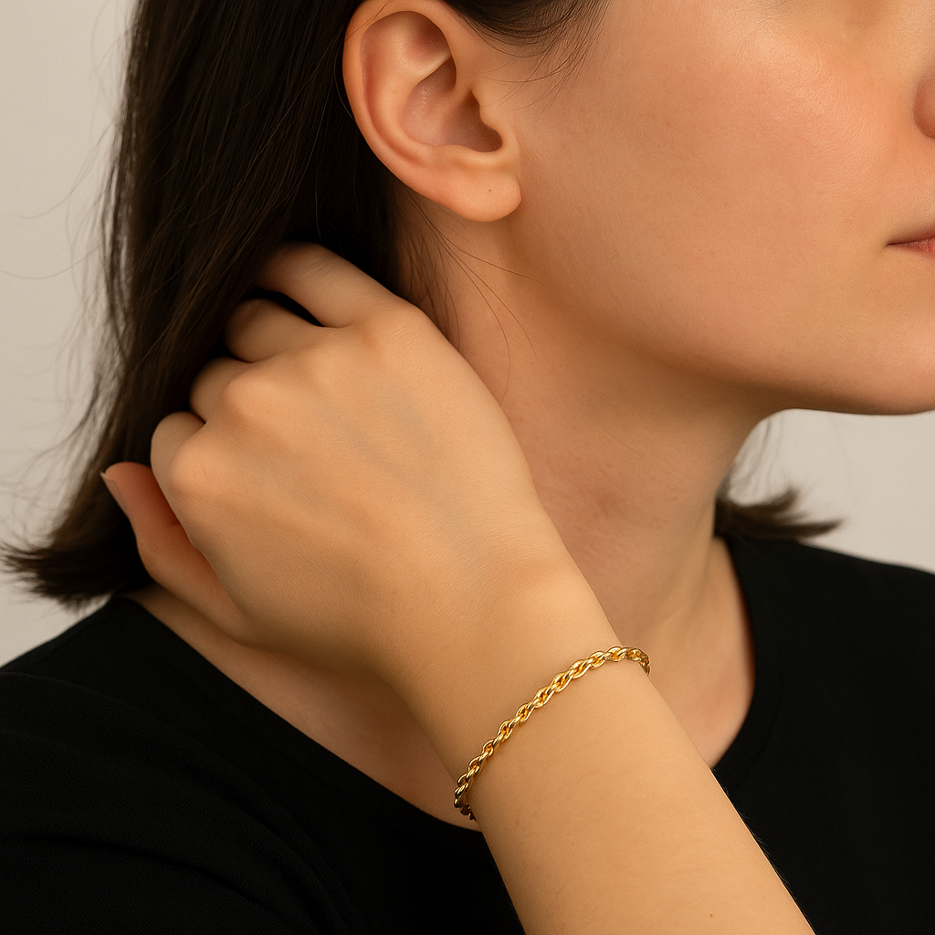 Gold braided rope bracelet on wrist with clasp detail