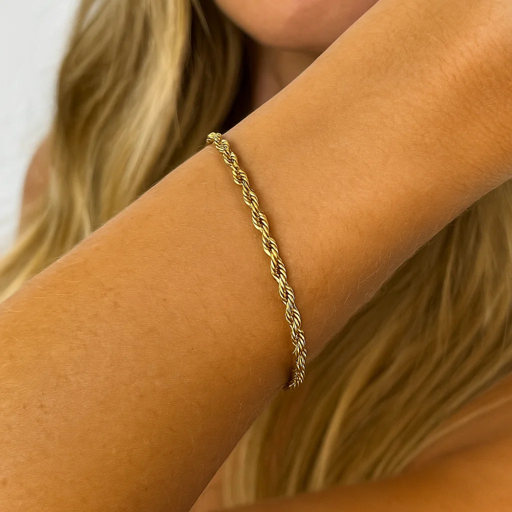 Gold rope bracelet with twisted chain links on bare wrist