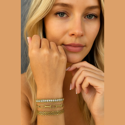Gold-tone CZ chain bracelet with stacked links and clear stones on model’s wrist.