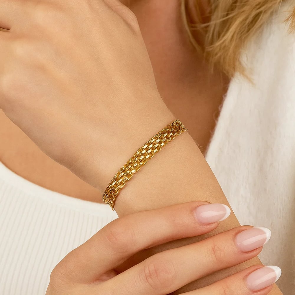 Gold tone adjustable link chain bracelet on wrist, close-up