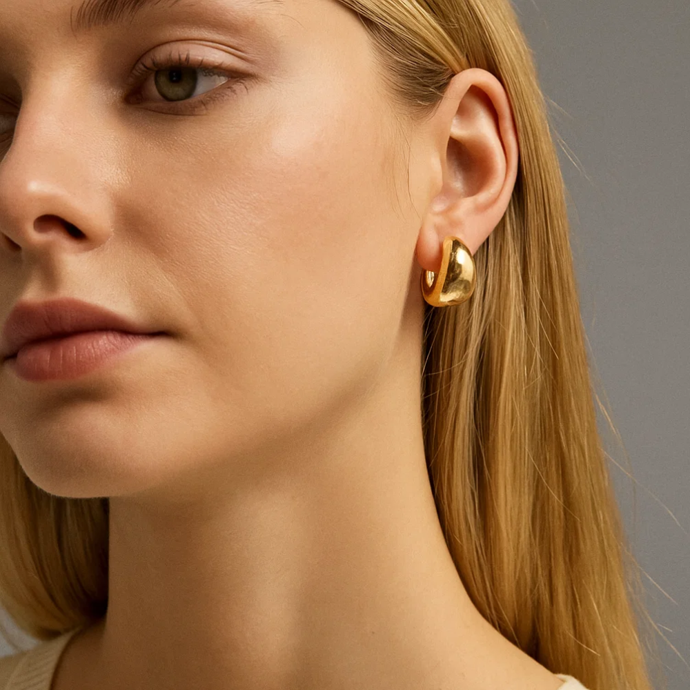 Gold dome huggie hoop earrings close-up on model