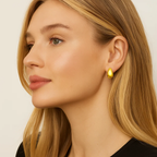 Gold dome huggie hoop earrings on model side profile