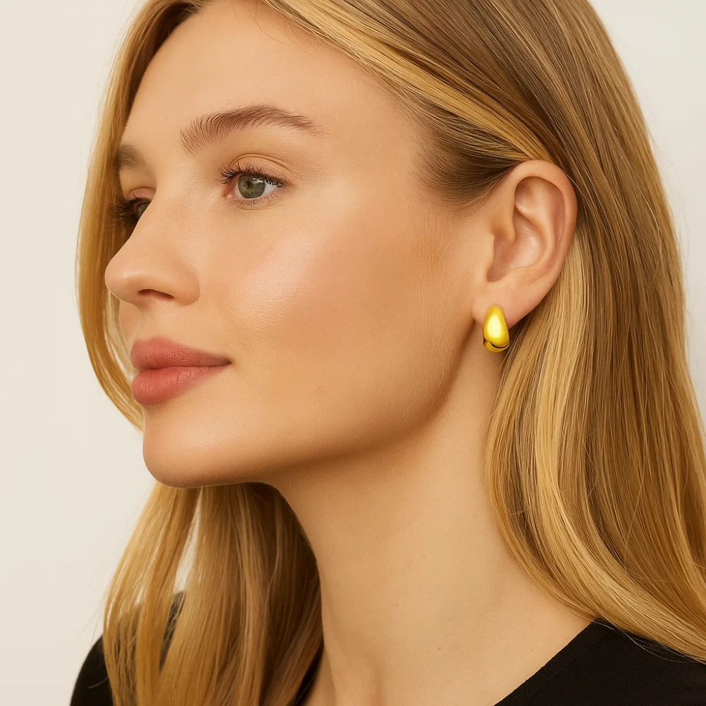 Gold dome huggie hoop earrings on model side profile