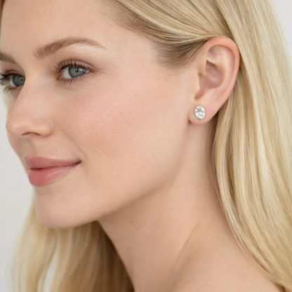 Gold oval-cut moissanite stud earrings on ear