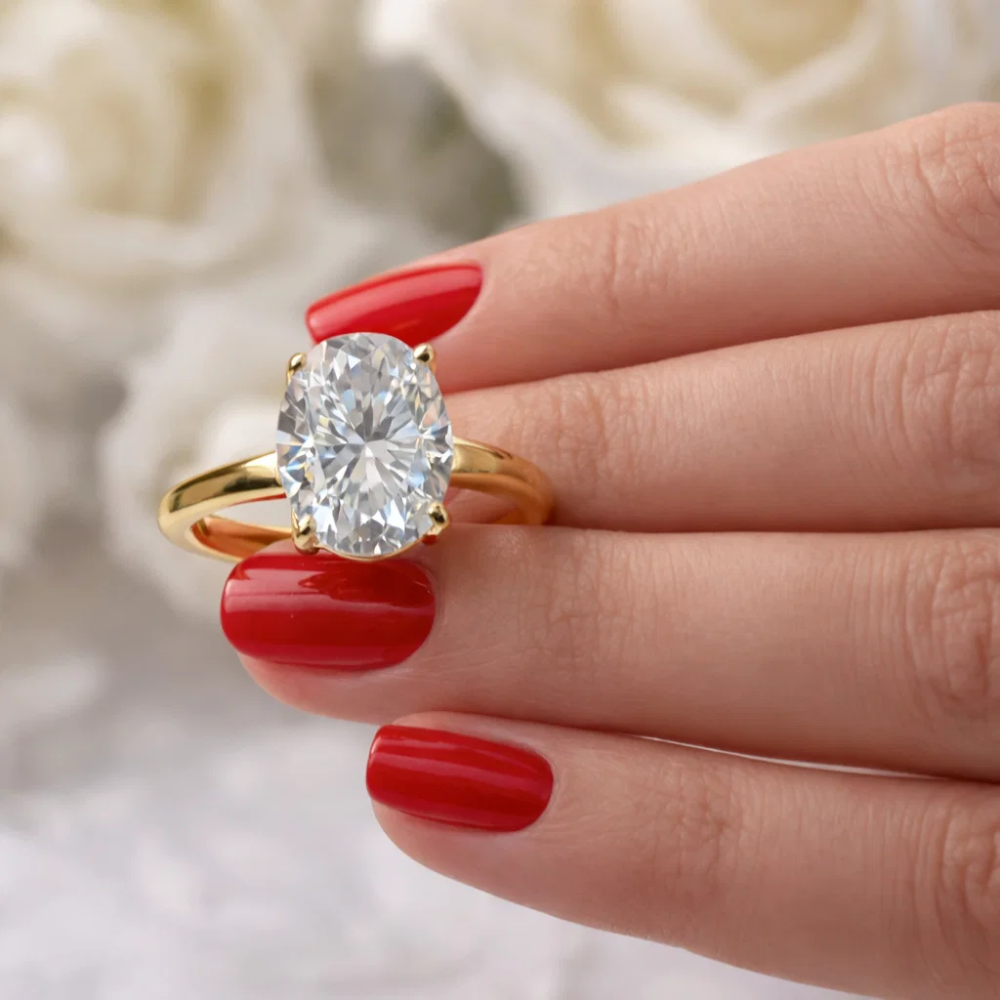 Gold-tone oval cut solitaire ring with four-prong setting and polished band