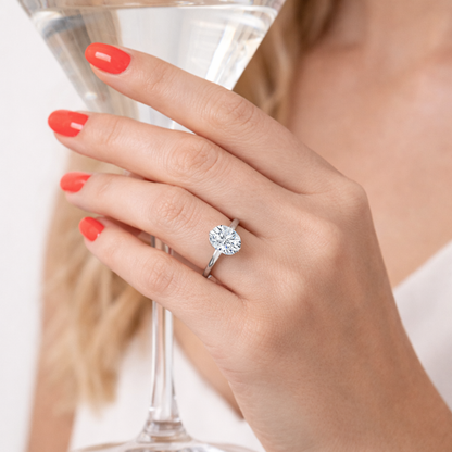 Silver-tone oval cut solitaire ring with four-prong setting on hand