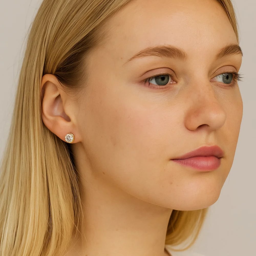 Gold-tone round crystal stud earrings on ear