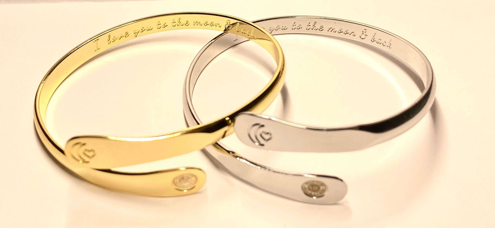Gold and silver moon-heart cuff bracelets side by side with round charm plates