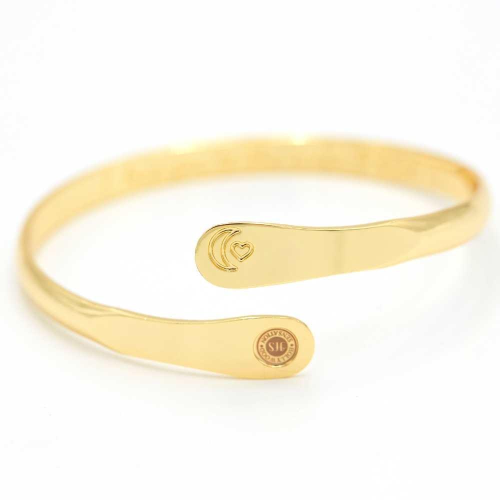 Gold moon and heart cuff bracelet with central oval detail and round charm plate
