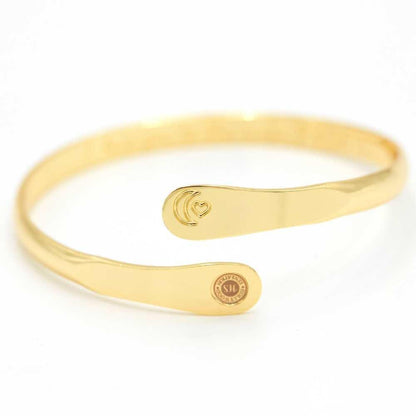 Gold moon and heart cuff bracelet with central oval detail and round charm plate