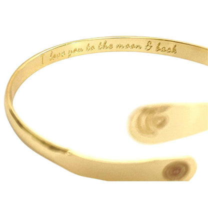 Gold tone cuff bracelet with engraved message along the inner band