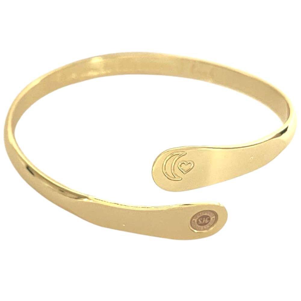 Gold tone cuff bracelet with moon and heart engraving on the front
