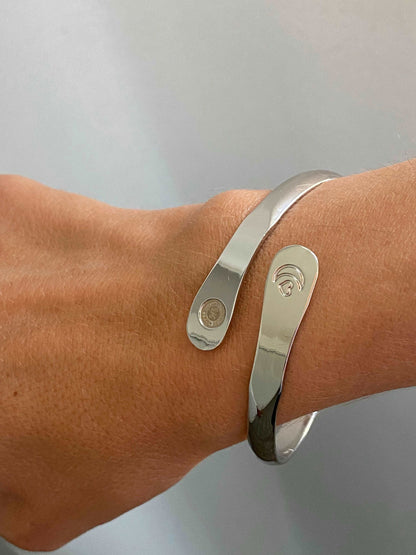 Silver engraved moon and heart cuff bracelet on wrist with round charm plate