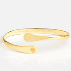 Gold engraved bangle bracelet underside with small round medallion charm