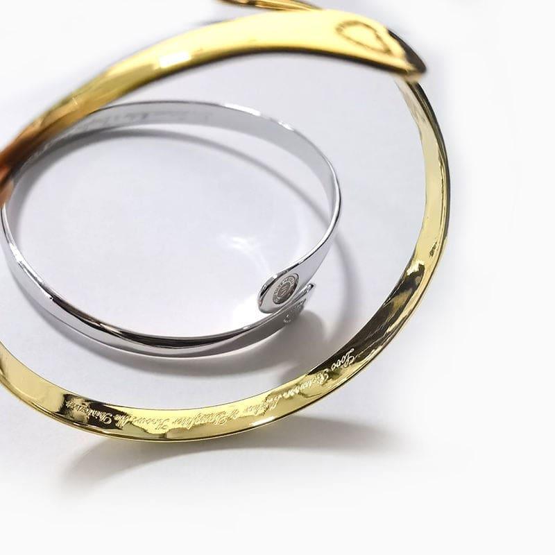 Gold and silver engraved cuff bracelets with small engraved marks on the bands