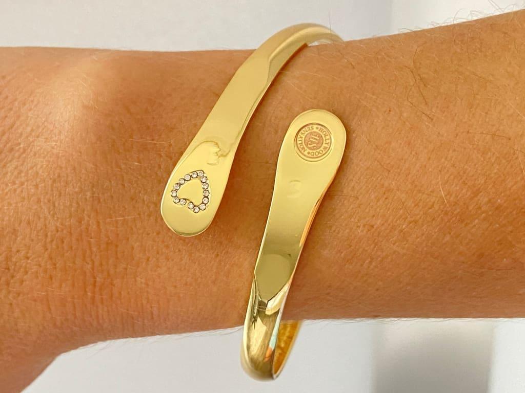 Gold mother-daughter bracelet set on wrist, heart rhinestone detail and round emblem