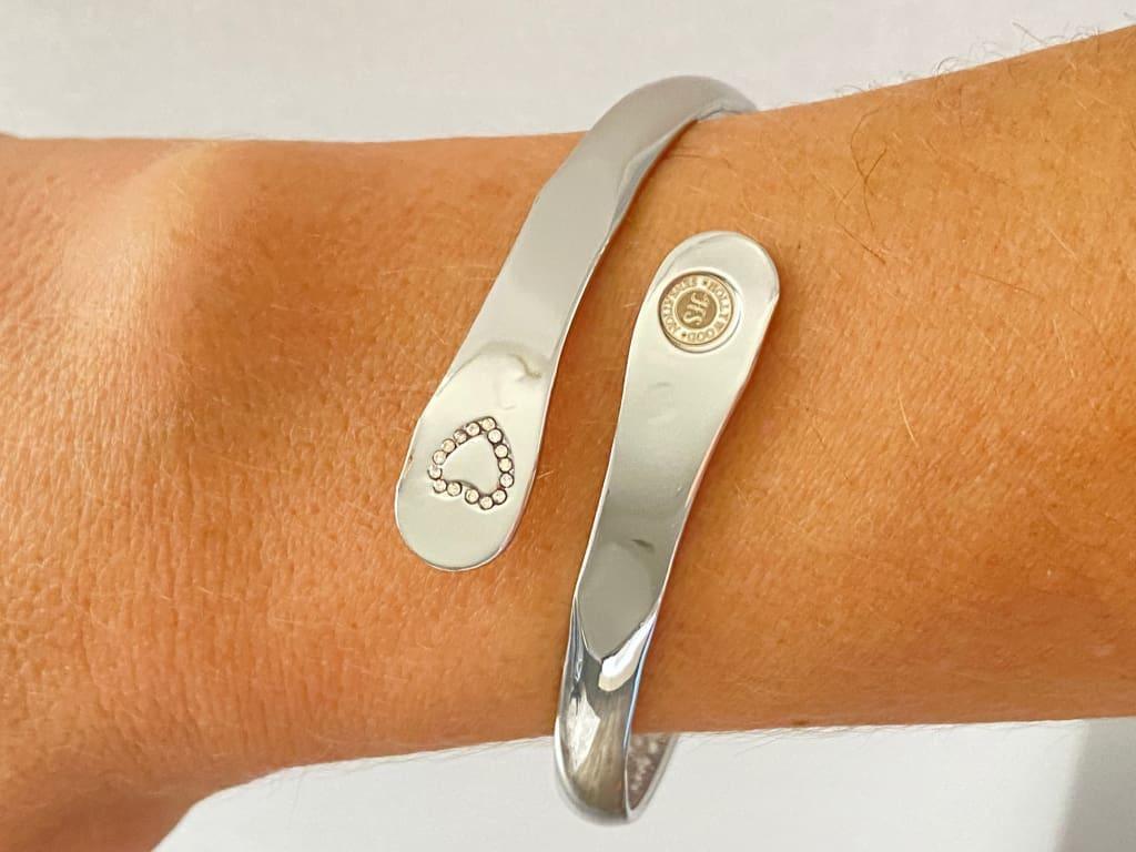 Silver mother-daughter bracelet set on wrist, heart rhinestone detail and round emblem