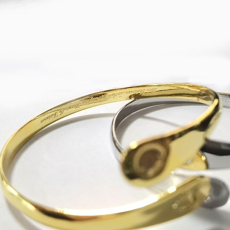 Gold engraved mother-daughter bracelet with circular emblem on the inner cuff