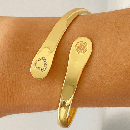 Gold mother-daughter bracelet set on wrist, heart rhinestone detail and round emblem